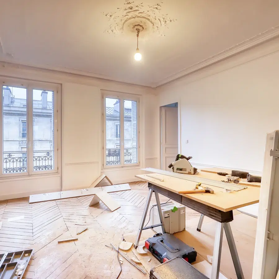 Salle en rénovation avec outils et parquet en cours de pose